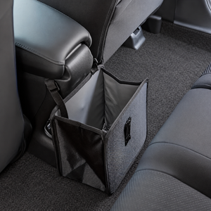 Open black hanging car bag beside a center console showing its gray lining and side mesh