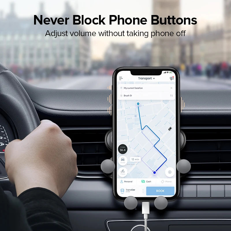 Phone holder positioned beside a steering wheel