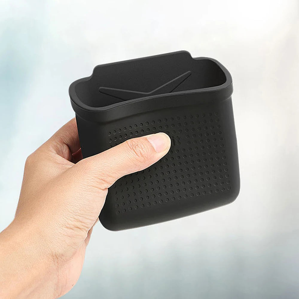 Hand holding a flexible black vehicle storage pocket