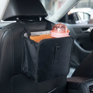 Hanging car bag holding small travel items behind a seat