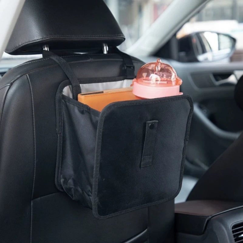 Hanging car bag holding small travel items behind a seat